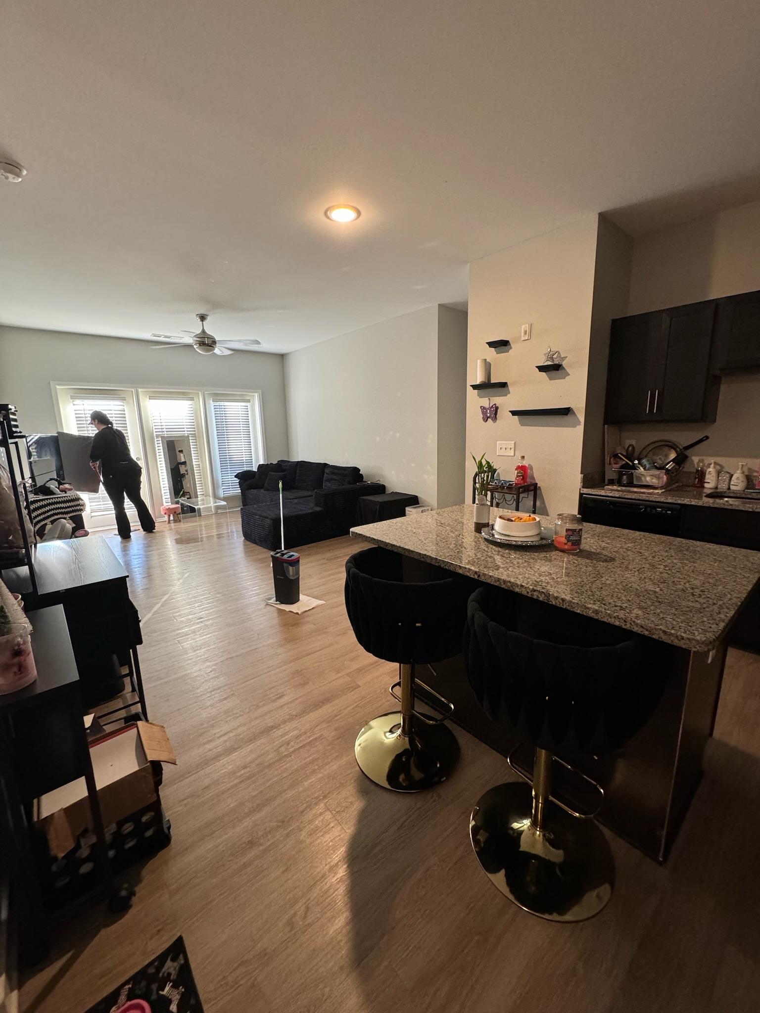 A tidy open-plan living room and kitchen island after a routine clean