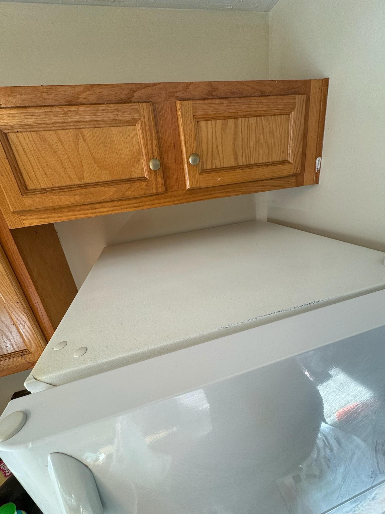 The same refrigerator top after cleaning, wiped back to bare white